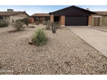 Southwest home with desert landscaping, rock ground cover, and a two-car garage at 4111 W Desert Cove Ave, Phoenix, AZ 85029