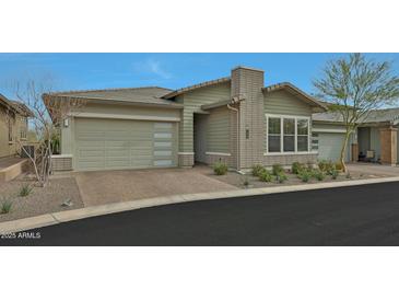 Charming single-story home featuring a two-car garage and a meticulously landscaped front yard at 5195 N 207Th Dr, Buckeye, AZ 85396