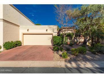 Charming home featuring a two-car garage, desert landscaping, and lovely curb appeal on a sunny day at 6701 N Scottsdale Rd # 15, Scottsdale, AZ 85250