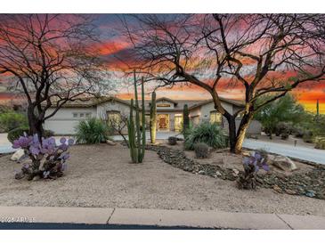 Desert home boasts mature landscaping, rock accents, and beautiful desert sunset at 8607 E Preserve Way, Scottsdale, AZ 85266