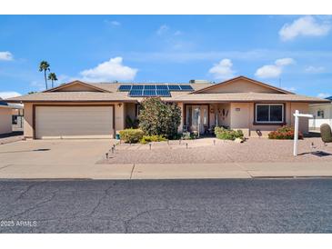 Charming home features a neutral color palette, solar panels, and well-maintained desert landscaping at 10842 W Sarabande Cir, Sun City, AZ 85351