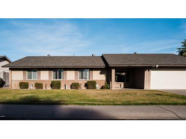 Charming single-story home with a well-manicured lawn, symmetrical design and an attached two-car garage at 13219 N 46Th Pl, Phoenix, AZ 85032
