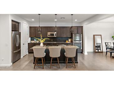 Modern kitchen with granite countertops, stainless steel appliances, and a large island at 18552 N 94Th St, Scottsdale, AZ 85255