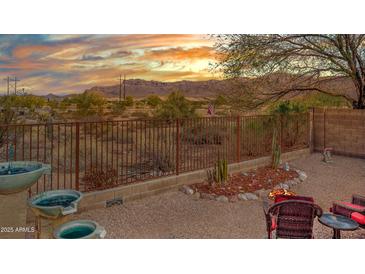 Relaxing backyard features a fire pit, comfortable seating, desert landscaping, and picturesque mountain views at 10356 E Meandering Trail Ln, Gold Canyon, AZ 85118