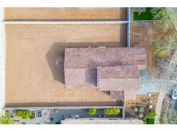 An aerial view of a single-Gathering home with a red tile roof surrounded by a dirt-filled lot at 12698 N 153Rd Ave, Surprise, AZ 85379