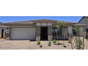 Charming single-story home features a manicured front yard, a two-car garage, and stone architectural accents at 21539 S 191St Pl, Queen Creek, AZ 85140
