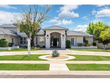 Elegant single-story home with a circular driveway, well-manicured lawn, and classic architectural details at 2251 N 32Nd St # 31, Mesa, AZ 85213