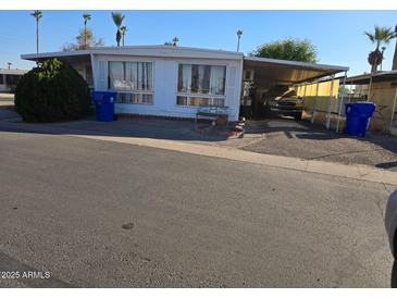 Charming single-story home with a carport and well-maintained landscaping in a mobile home community at 5201 W Camelback Rd # Ofc, Phoenix, AZ 85031
