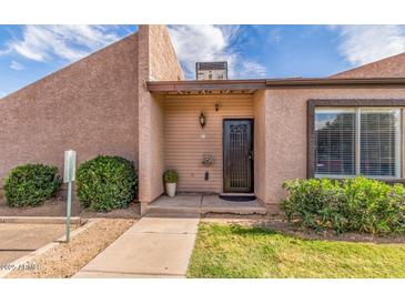 Inviting front entrance with a secure screen door and well-maintained landscaping at 629 N Mesa Dr # 18, Mesa, AZ 85201