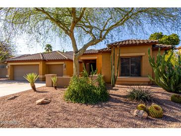 Charming single-story home features desert landscaping, a two-car garage and a tiled roof at 6820 W Angela Dr, Glendale, AZ 85308