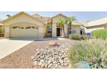 Inviting single-story home with desert landscaping, complemented by a two-car garage and tiled roof at 832 N Blue Marlin Dr, Gilbert, AZ 85234