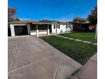 Charming single-story home with well-maintained lawn, neutral exterior, and concrete driveway at 1017 S Lola Ln, Tempe, AZ 85281