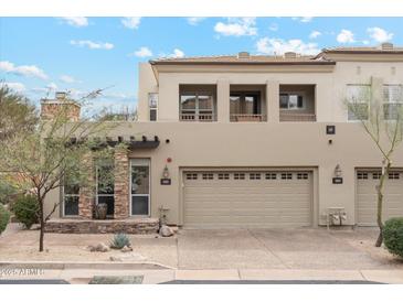 Inviting townhome featuring stone accents, a two-car garage, and a charming front yard at 28990 N White Feather E Ln # 182, Scottsdale, AZ 85262
