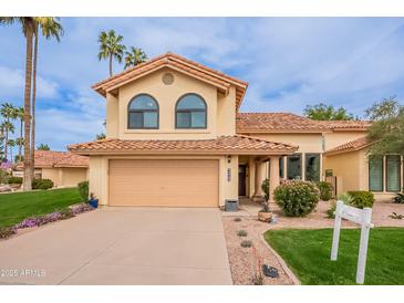Charming two-story home featuring a well-manicured lawn, desert landscaping, and a two-car garage at 11731 N 91St Pl, Scottsdale, AZ 85260