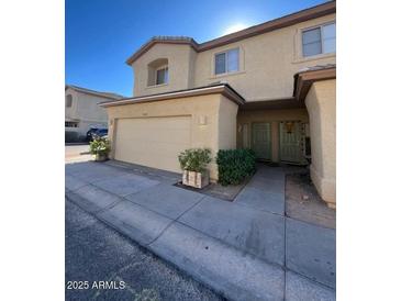 Charming townhouse with a two-car garage and welcoming front entrance with beautiful desert landscaping at 15655 N 29Th St, Phoenix, AZ 85032