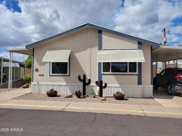 Charming manufactured home with desert landscaping, carport, and neutral color scheme under cloudy skies at 2460 E Main St # A2, Mesa, AZ 85213