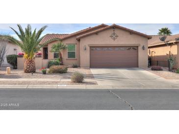 Charming single-story home with well-maintained landscaping and a brown two-car garage at 2611 E San Simeon Dr, Casa Grande, AZ 85194