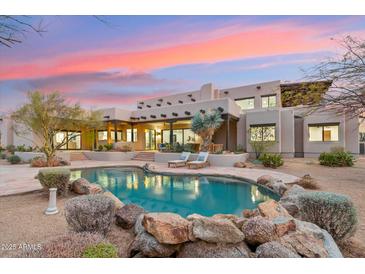 Inviting pool area with rock features and comfortable lounge seating at this luxury property at sunset at 30600 N Pima Rd # 76, Scottsdale, AZ 85266