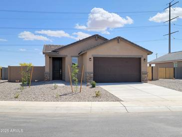 Charming single-story home with a desert-landscaped front yard and a two-car garage at 318 S San Fernando Ln, Casa Grande, AZ 85194