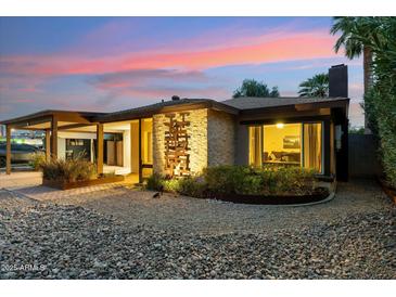 Charming home exterior featuring a stone facade, desert landscaping, and illuminated accents at 4130 N 4Th Ave, Phoenix, AZ 85013