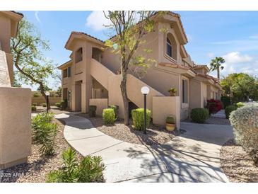 Beautiful exterior view of a two-story condo featuring well-maintained landscaping and a pathway at 5450 E Mclellan Rd # 102, Mesa, AZ 85205