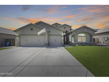 Charming single-story home featuring a three-car garage, stone accents and a well-manicured lawn at 854 S Del Rio Ct, Apache Junction, AZ 85120