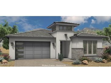 Modern prairie-style home featuring a two-car garage, decorative brick, and clerestory above the entry at 21450 W Meadowbrook Ave, Buckeye, AZ 85396