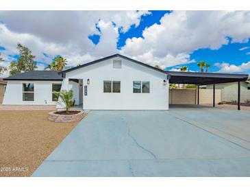 Charming single-story home with modern black and white trim and a covered carport at 4036 E Captain Dreyfus Ave, Phoenix, AZ 85032