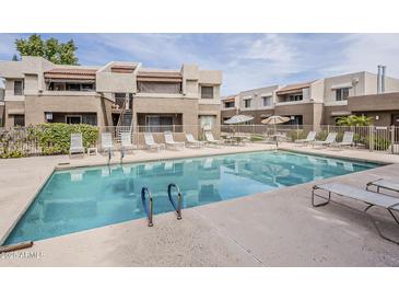 Resort-style pool with lounge chairs offer a relaxing oasis for residents of this inviting condo complex at 4554 E Paradise Village N Pkwy # 249, Phoenix, AZ 85032