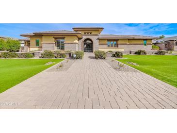 Inviting front exterior with manicured lawn, stone accents, and a secure gated entrance at 2830 E Fruitvale Ave, Gilbert, AZ 85297