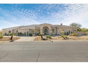 Charming single-story home with desert landscaping, circular driveway, and arched windows at 9826 N 131St St, Scottsdale, AZ 85259