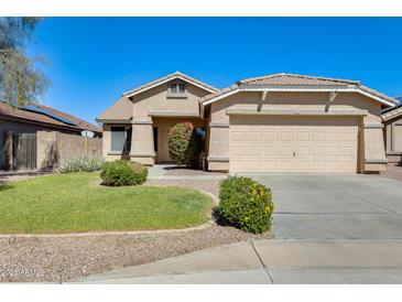 Charming single-story home with a well-manicured lawn and a two-car garage at 13536 W Peck Dr, Litchfield Park, AZ 85340