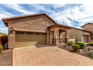 Charming brick home featuring a two-car garage and welcoming front porch, set against a beautiful blue sky at 1631 N Lynch --, Mesa, AZ 85207