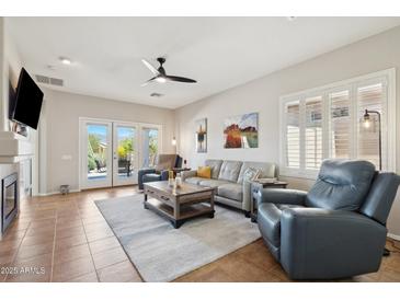 Bright living room featuring tile floors, ceiling fan, neutral paint, and access to the backyard at 10134 E Meandering Trail Ln, Gold Canyon, AZ 85118
