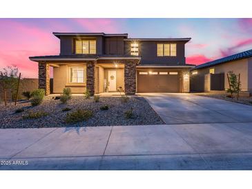 Charming two-story home featuring a well-manicured front yard and an attached two-car garage at 19443 W Valle Vista Way, Litchfield Park, AZ 85340