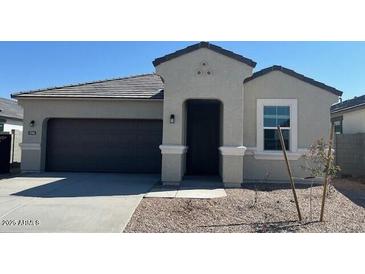 Charming single-story home featuring a two-car garage and simple desert landscaping at 25461 W Graham Trl, Buckeye, AZ 85326