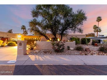 Charming single-story home with desert landscaping, mature trees, and a well-maintained stucco facade at sunset at 3258 E Vogel Ave, Phoenix, AZ 85028