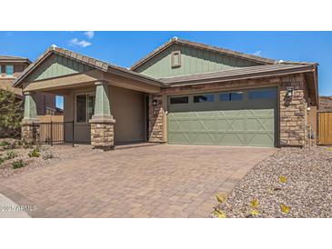 Charming home featuring stone accents, a two-car garage, and a brick paved driveway at 33395 N 132Nd Dr, Peoria, AZ 85383