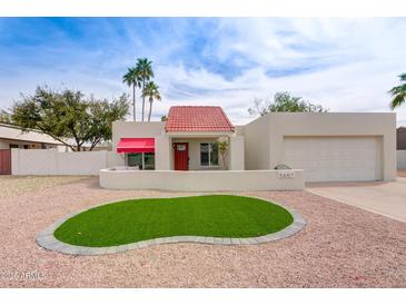 Charming home featuring a red tile roof, desert landscaping, and a manicured lawn at 5607 N 76Th Pl, Scottsdale, AZ 85250