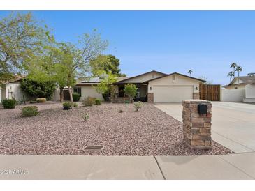 Charming single-story home with a two-car garage, low-maintenance landscaping, and desert accents at 12809 N 50Th St, Scottsdale, AZ 85254