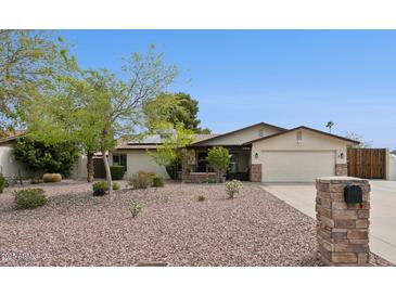 Charming single-story home with desert landscaping, stone accents, and a two-car garage under a clear blue sky at 12809 N 50Th St, Scottsdale, AZ 85254