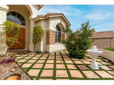 Charming front yard featuring a unique tiled lawn and a decorative fountain at 3110 E Desert Flower Ln, Phoenix, AZ 85048