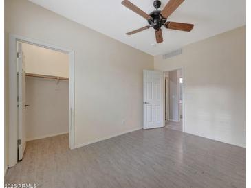 Neutral bedroom with a ceiling fan, en-suite bathroom, walk-in closet, and tile floor at 6221 S 45Th Gln, Laveen, AZ 85339