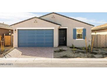 Charming single-story home with a blue garage door, stone accents, and desert landscaping at 8613 W Warner St, Tolleson, AZ 85353