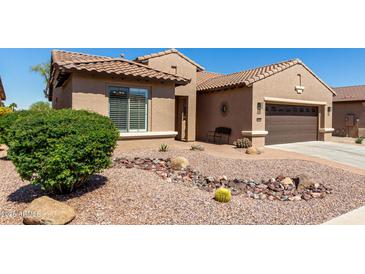 Charming single-story home showcasing desert landscaping and a two-car garage at 15696 W Roanoke Ave, Goodyear, AZ 85395