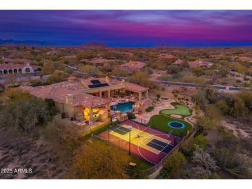 Stunning aerial view of a private estate featuring a pool, sports court, putting green, and lush desert landscaping at 27632 N 68Th Pl, Scottsdale, AZ 85266