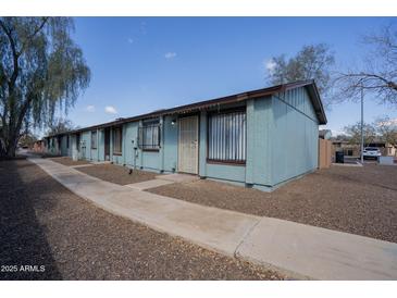 Charming blue apartment building with decorative bars, rock landscaping, and a well-maintained walkway at 3646 N 67Th Ave # 12, Phoenix, AZ 85033