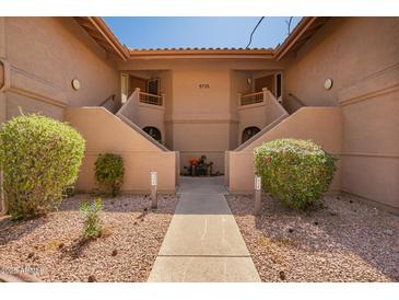 Inviting condo exterior with well-maintained landscaping and dual staircase access at 9735 N 94Th Pl # 110, Scottsdale, AZ 85258