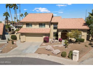 Beautiful two-story home with a terracotta roof, desert landscaping, and an inviting water feature in the front yard at 5530 E Beck Ln, Scottsdale, AZ 85254