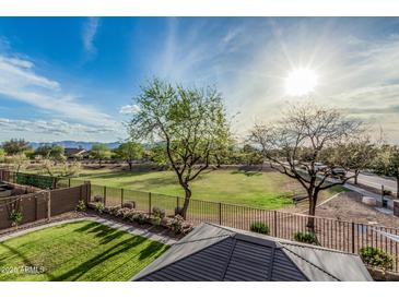 Lush backyard view with a green lawn, mature trees, and a charming gazebo at 6804 S 45Th Gln, Laveen, AZ 85339